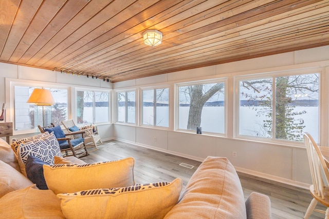 sunroom featuring a water view and wood ceiling