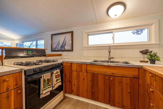 kitchen with plenty of natural light, white gas range, sink, and light wood-type flooring