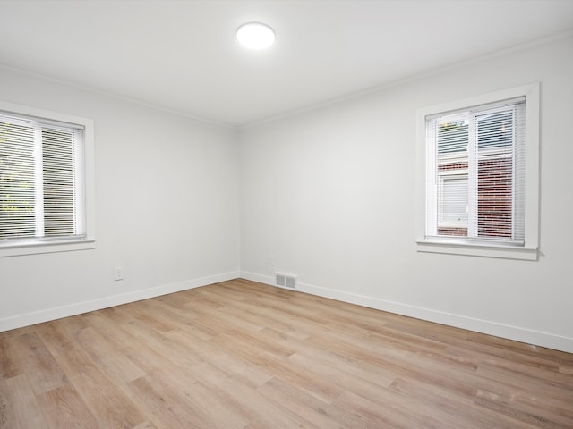 empty room featuring ornamental molding and light hardwood / wood-style floors