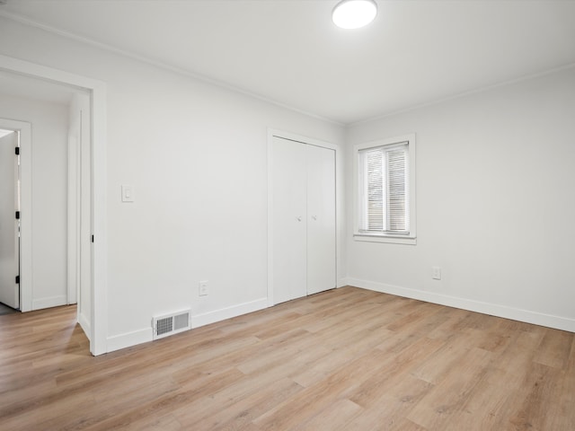 spare room featuring ornamental molding and light hardwood / wood-style flooring