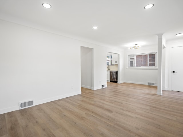 unfurnished living room featuring sink and light hardwood / wood-style floors