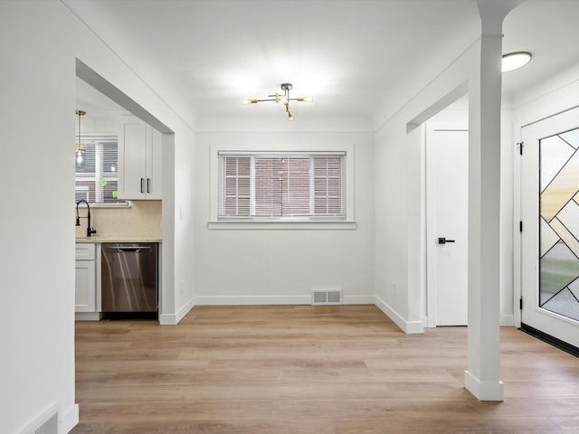 unfurnished dining area featuring sink, a wealth of natural light, and light hardwood / wood-style flooring