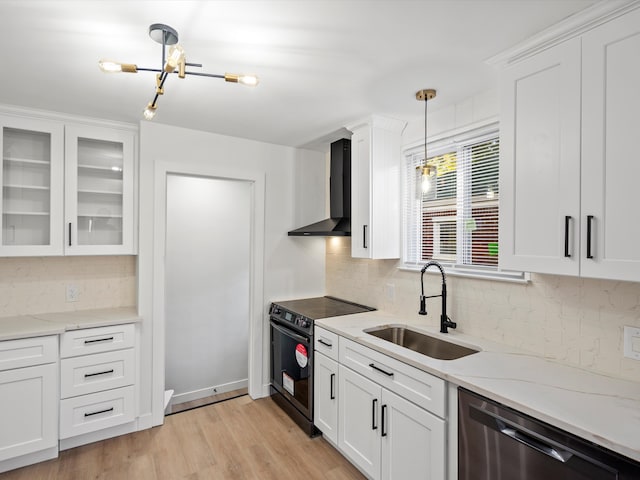 kitchen with pendant lighting, sink, white cabinets, black range with electric cooktop, and wall chimney exhaust hood