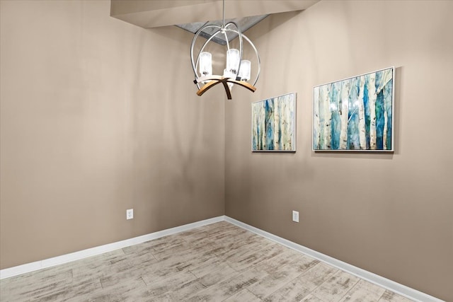 unfurnished dining area featuring light hardwood / wood-style flooring and a chandelier