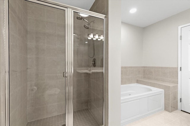 bathroom featuring tile patterned flooring, independent shower and bath, and tile walls