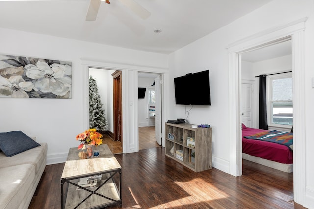 living room with dark wood-type flooring and ceiling fan