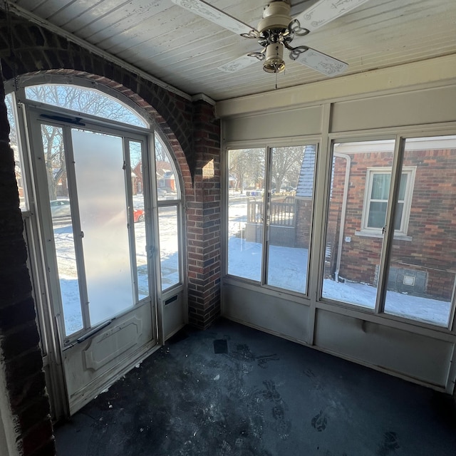 unfurnished sunroom featuring a wall unit AC, wooden ceiling, and ceiling fan