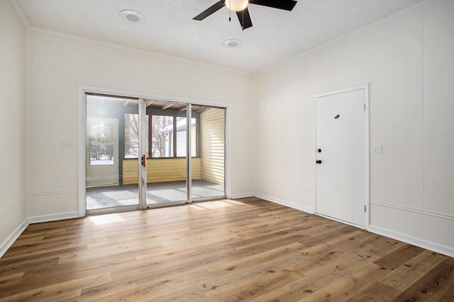 unfurnished room featuring hardwood / wood-style flooring, ceiling fan, ornamental molding, and a textured ceiling