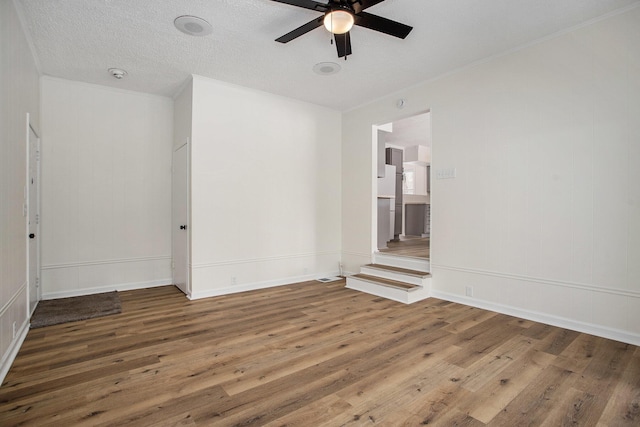 spare room with crown molding, ceiling fan, hardwood / wood-style floors, and a textured ceiling