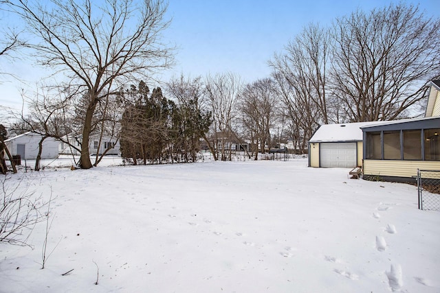 snowy yard with a garage