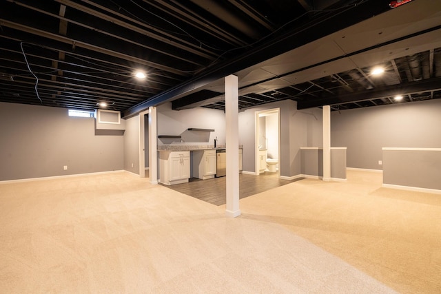 basement featuring sink and light carpet