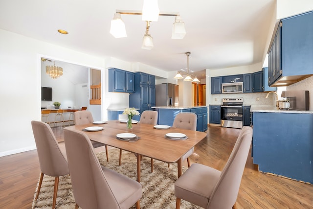 dining room with a notable chandelier and light wood-type flooring