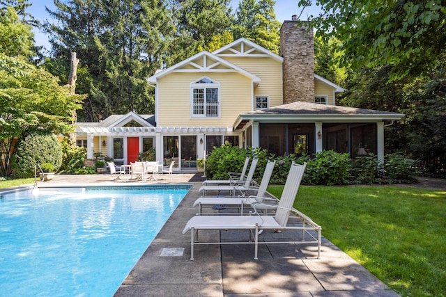 view of pool featuring a patio, a sunroom, a yard, and a pergola