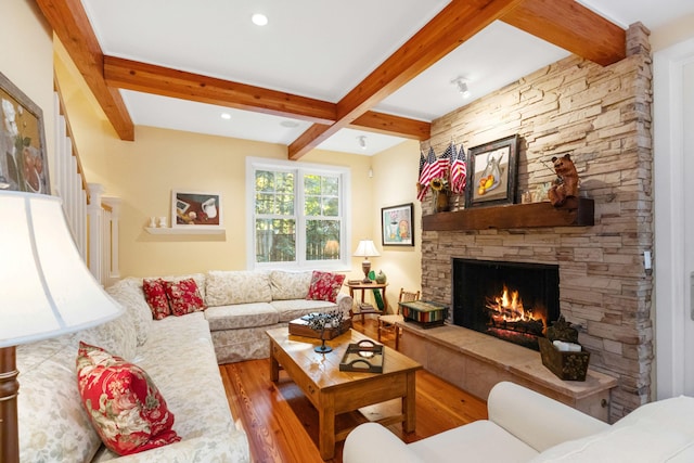 living room with hardwood / wood-style flooring, a fireplace, and beamed ceiling