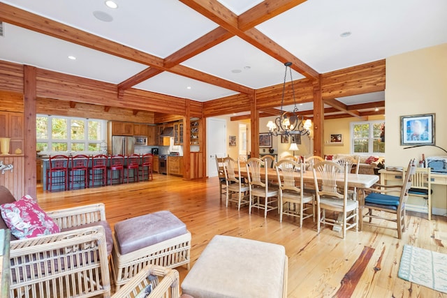 dining room featuring beamed ceiling, an inviting chandelier, coffered ceiling, and light hardwood / wood-style floors