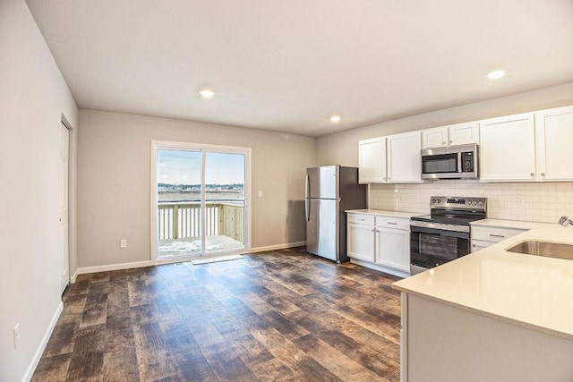 kitchen featuring appliances with stainless steel finishes, sink, decorative backsplash, and white cabinets