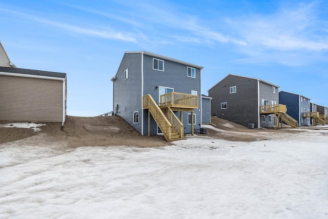 snow covered back of property featuring a wooden deck