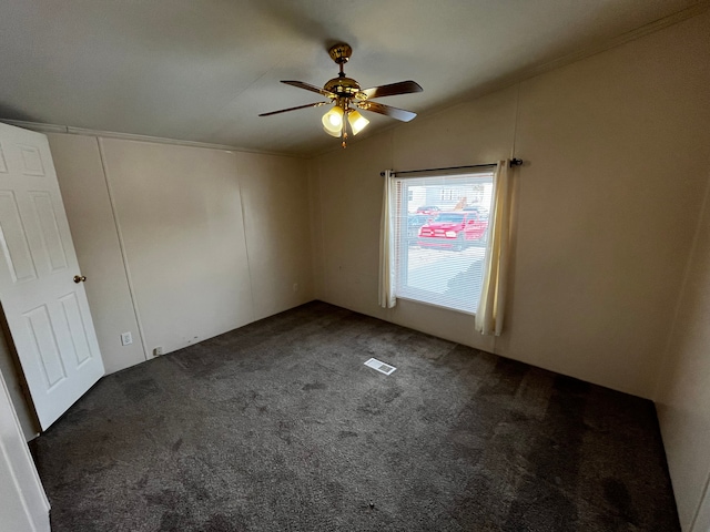 carpeted spare room featuring lofted ceiling and ceiling fan