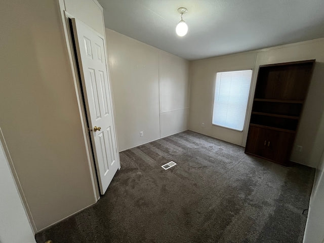 unfurnished bedroom featuring dark carpet