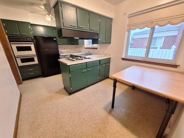 kitchen featuring black fridge, green cabinetry, and a healthy amount of sunlight