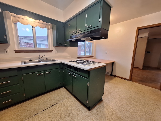 kitchen featuring green cabinetry, plenty of natural light, sink, and white gas cooktop