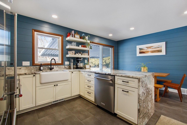 kitchen with sink, plenty of natural light, stainless steel dishwasher, and light stone countertops