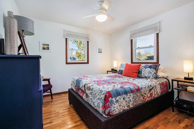 bedroom with multiple windows, light hardwood / wood-style flooring, and ceiling fan