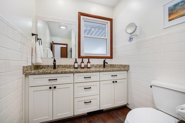 bathroom with tile walls, vanity, hardwood / wood-style floors, and toilet