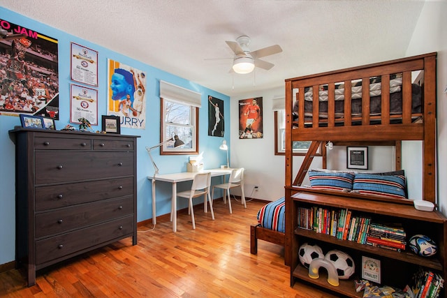 bedroom with a textured ceiling and light wood-type flooring