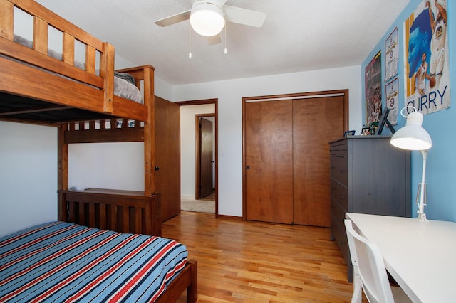 bedroom with ceiling fan, a closet, a textured ceiling, and light wood-type flooring