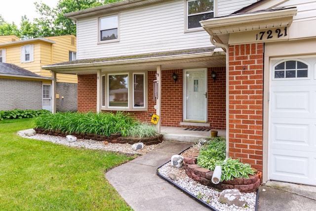 property entrance featuring a garage, covered porch, and a lawn