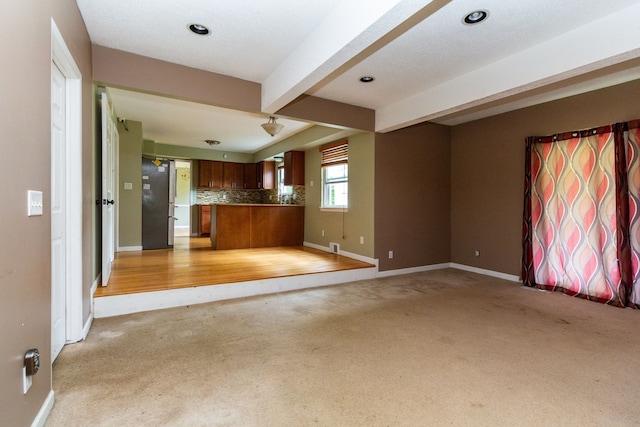 interior space with light colored carpet and beamed ceiling