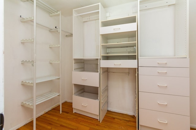 walk in closet with hardwood / wood-style flooring