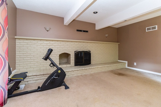 exercise room with carpet floors and a brick fireplace