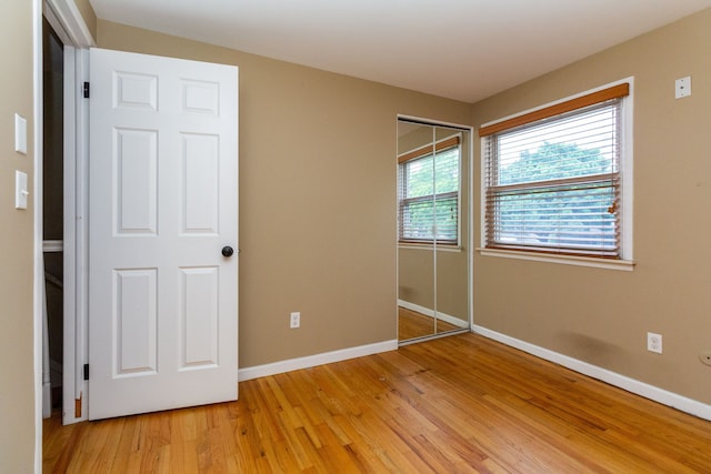 unfurnished bedroom featuring light wood-type flooring and a closet