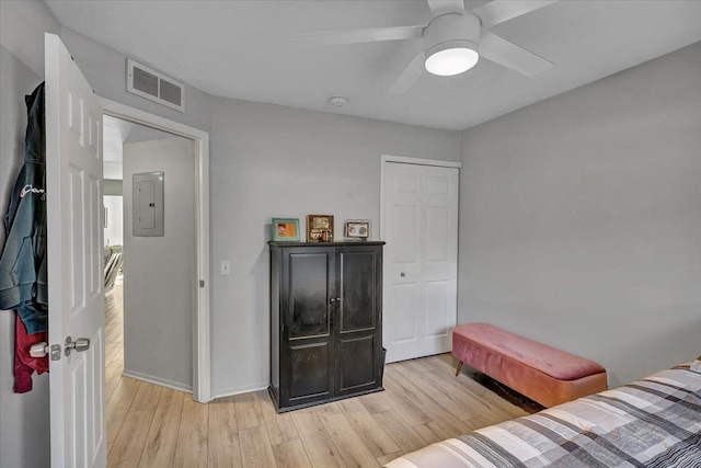 bedroom with ceiling fan, electric panel, and light hardwood / wood-style floors