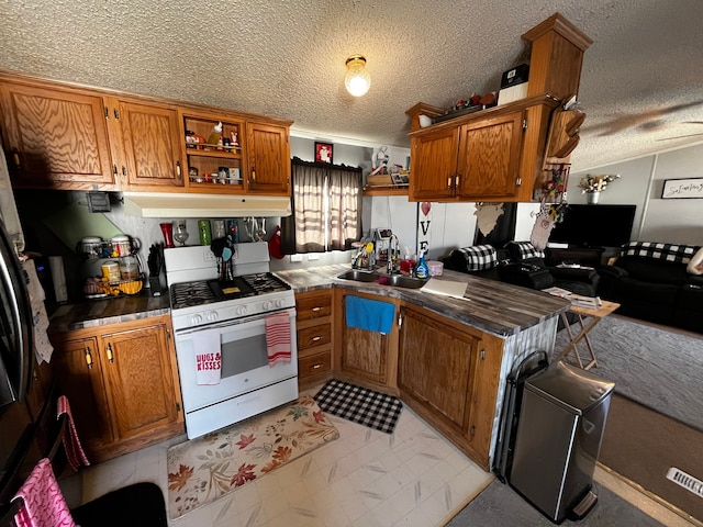 kitchen featuring kitchen peninsula, sink, white range with gas stovetop, and a textured ceiling