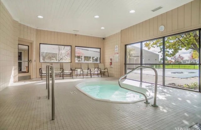 view of swimming pool featuring an indoor hot tub