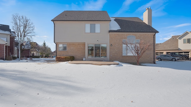 view of snow covered rear of property