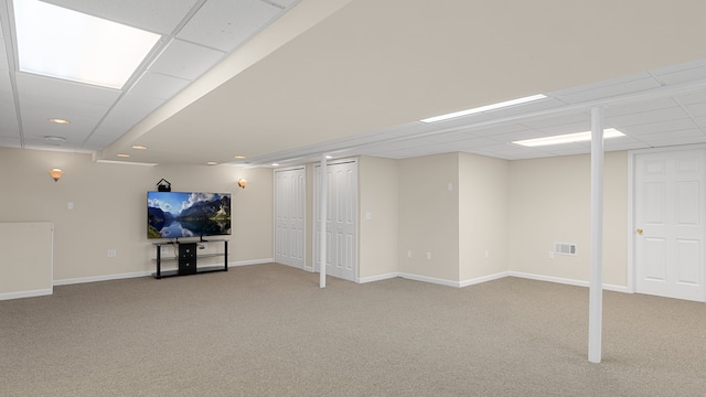 basement with light colored carpet and a drop ceiling