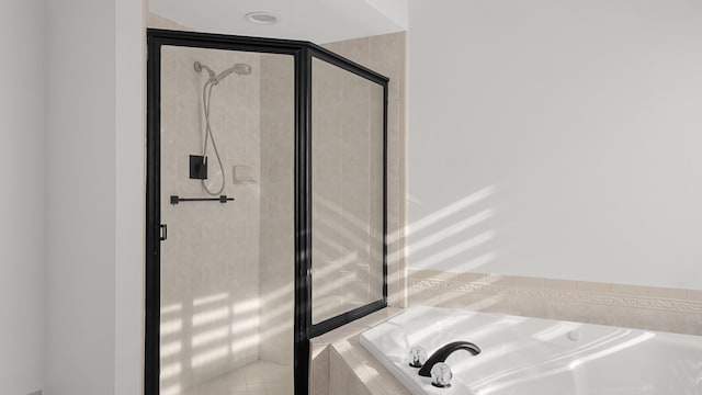 bathroom featuring shower with separate bathtub