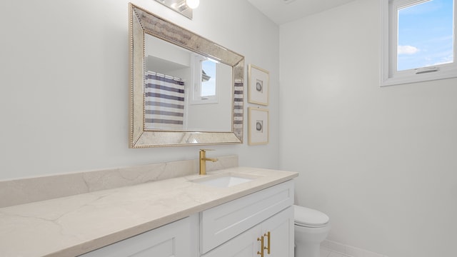 bathroom featuring a shower with curtain, vanity, a wealth of natural light, and toilet