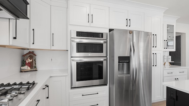 kitchen featuring white cabinetry, appliances with stainless steel finishes, and exhaust hood