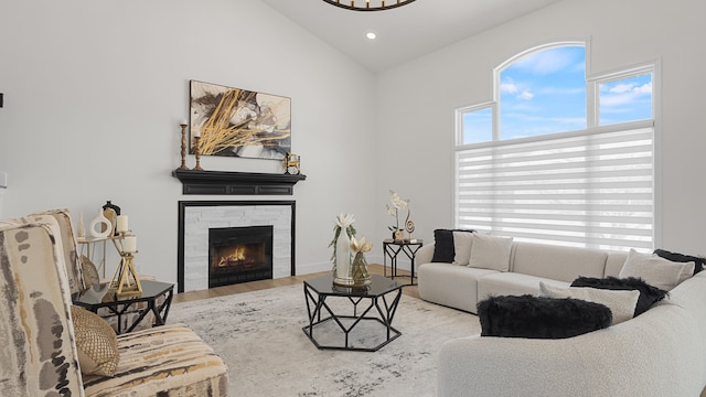 living room featuring hardwood / wood-style flooring, a tile fireplace, and high vaulted ceiling