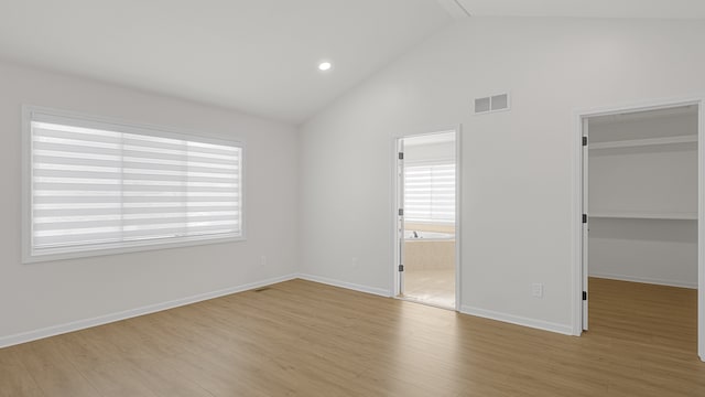 unfurnished bedroom featuring a walk in closet, light hardwood / wood-style floors, and a closet