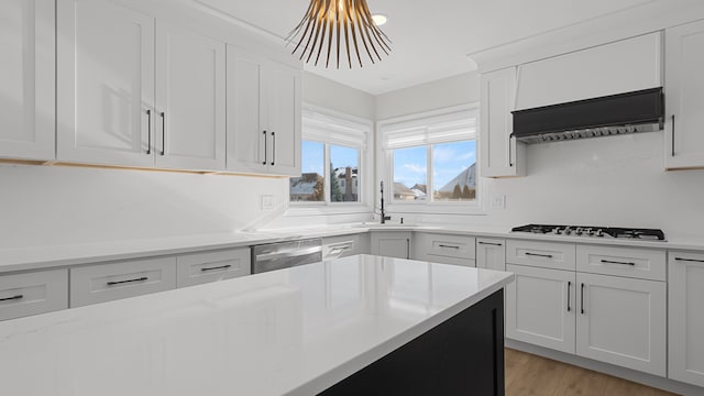 kitchen featuring sink, white cabinetry, gas stovetop, light hardwood / wood-style floors, and stainless steel dishwasher