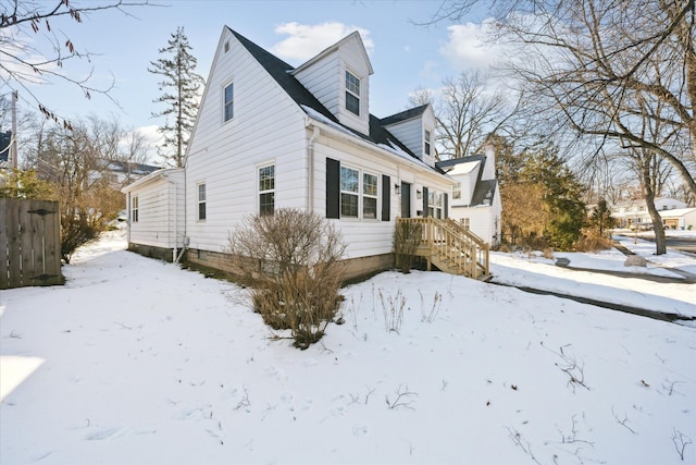 snow covered property featuring fence