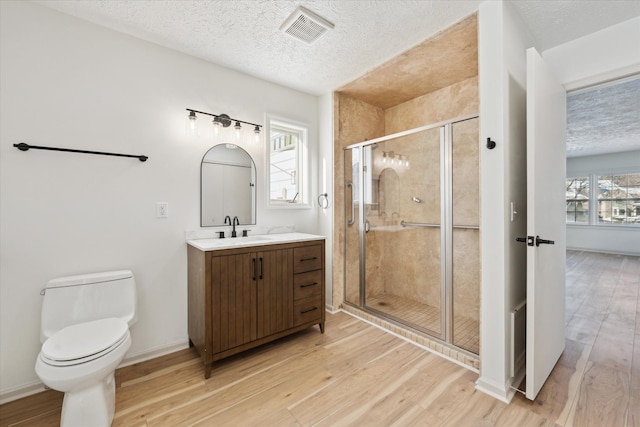 full bathroom featuring visible vents, wood finished floors, and a shower stall