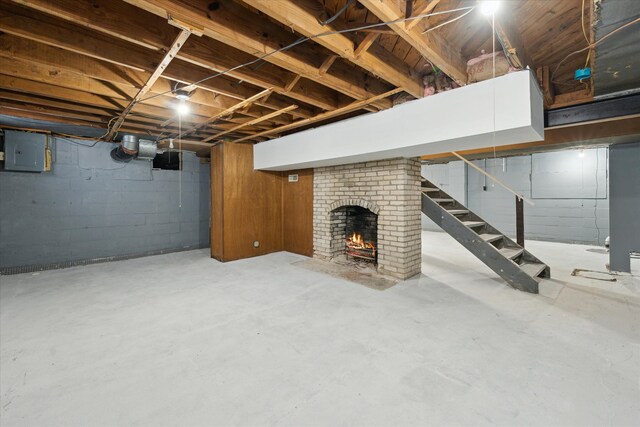 basement featuring a brick fireplace and electric panel