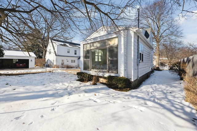 view of front facade featuring fence, an outdoor structure, and a sunroom